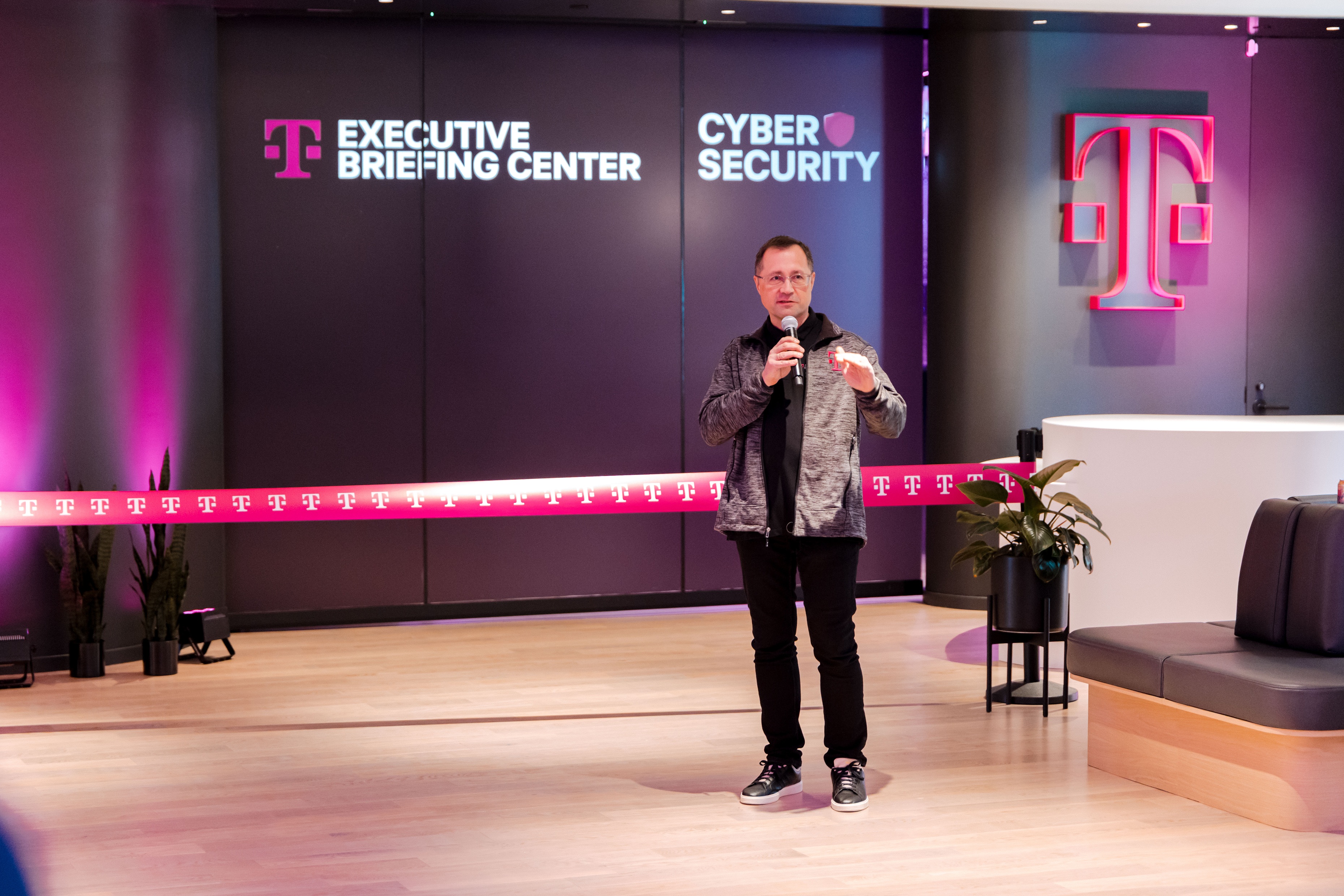 Dmitry Risukhin at the mic in front of the joint EBC and Cyber Defense Center signage